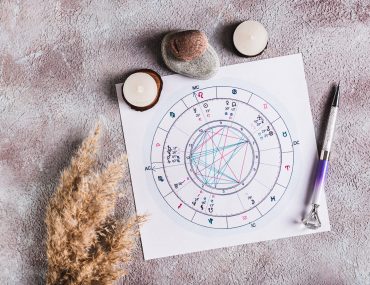 Close up of personal natal chart for fortune telling and pen on the table top view